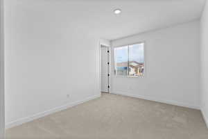Unfurnished room featuring light colored carpet and baseboards