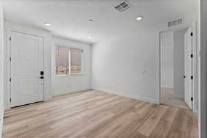 Foyer entrance featuring light wood finished floors and recessed lighting