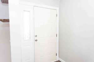 Doorway to outside featuring baseboards