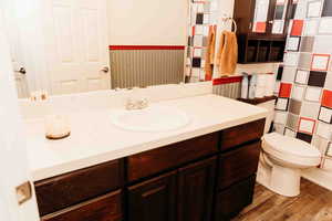 Bathroom with vanity, light wood-style flooring, and wainscoting