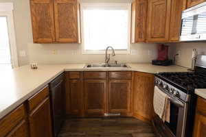 Kitchen with stainless steel appliances, plenty of natural light, oak cabinetry, and light countertops
