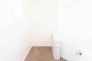 Walk in master closet with dark carpet