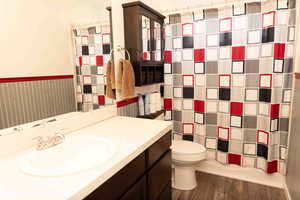 Bathroom featuring dark wood-style floors, vanity, and shower / bath combo with shower curtain
