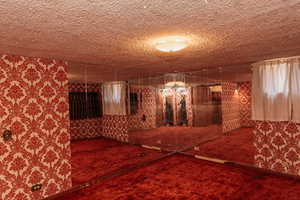 Bedroom featuring wallpapered & mirrored walls