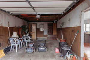 Garage featuring wooden walls and a garage door opener