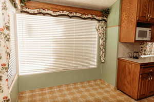 Eat in Kitchen/dining  featuring light countertops, oak cabinets, white microwave, and light floors