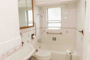 Full bath featuring shower / tub combination, pedestal sink and toilet