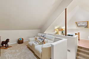 Sitting room featuring vaulted ceiling and carpet floors