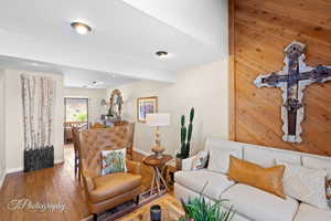 Living room with hardwood / wood-style floors and wooden walls