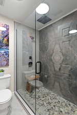 Full bathroom featuring a stall shower and toilet