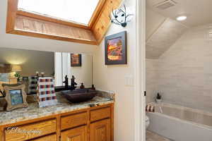 Bathroom featuring vanity, light tile patterned floors, and bathing tub / shower combination