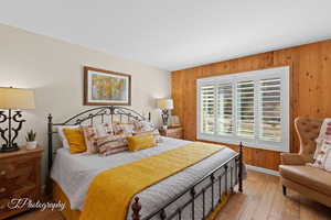 Bedroom with wooden walls and wood-type flooring