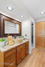 Full bathroom featuring vanity, light wood-type flooring, a stall shower, and recessed lighting