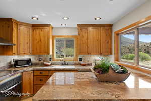 Kitchen featuring backsplash, stainless steel appliances, plenty of natural light, brown cabinetry, and recessed lighting