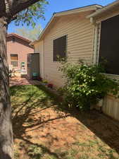 View of property exterior with a lawn and a patio area
