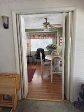 Dining room with a textured wall, wood finished floors, and a ceiling fan