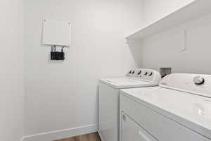 Laundry room featuring separate washer and dryer and wood finished floors