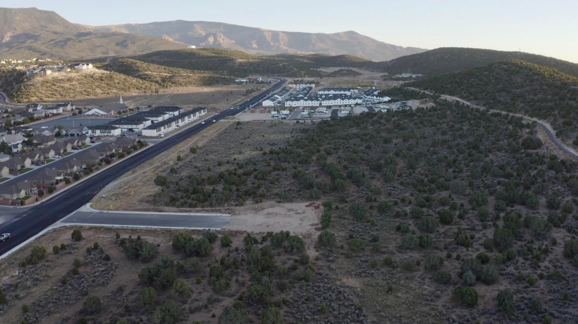 Aerial view of property and surrounding area featuring a mountain backdrop