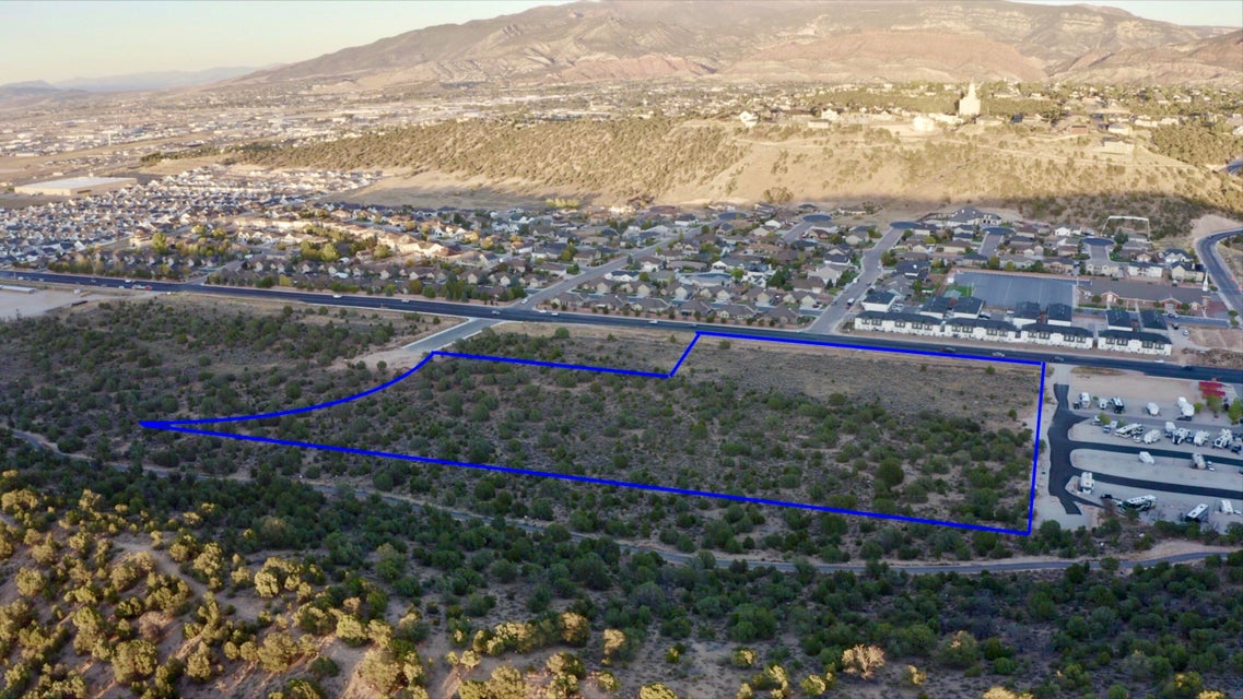 Aerial view of residential area with property boundaries highlighted and a mountain backdrop