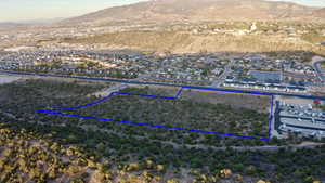 Aerial view of residential area with property boundaries highlighted and a mountain backdrop