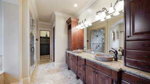 Full bathroom featuring crown molding, a stall shower, double vanity, light tile patterned flooring, and a spacious closet