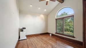 Spare room with high vaulted ceiling, a ceiling fan, hardwood / wood-style floors, and beam ceiling