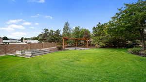 View of yard featuring a garden, a pergola, and a patio