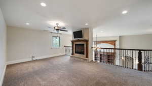 Unfurnished living room with carpet floors, recessed lighting, a chandelier, and a ceiling fan