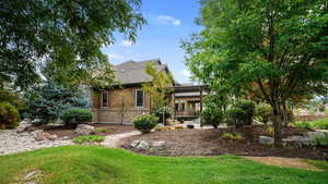 Back of property with a lawn, a shingled roof, and brick siding