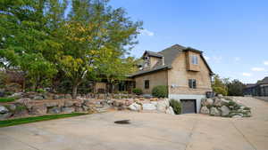 View of front of home featuring driveway, stucco siding, a garage, and a shingled roof