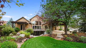 Back of property featuring a patio, a yard, stucco siding, and a balcony