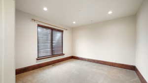 Carpeted spare room featuring recessed lighting and baseboards