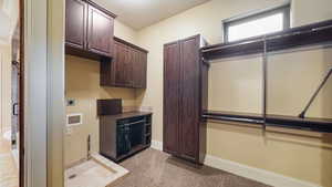 Washroom featuring light carpet, cabinet space, hookup for a washing machine, and hookup for an electric dryer