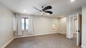 Carpeted empty room with ceiling fan and recessed lighting