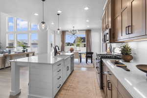 Kitchen featuring open floor plan, appliances with stainless steel finishes, light stone countertops, and recessed lighting