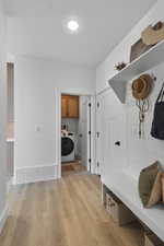 Mudroom with light wood finished floors and washer / clothes dryer
