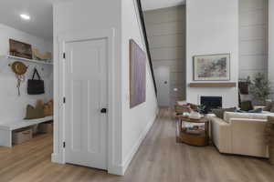 Living room featuring a glass covered fireplace and light wood-type flooring