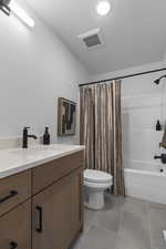 Full bathroom featuring vanity, shower / tub combo with curtain, and light tile patterned flooring