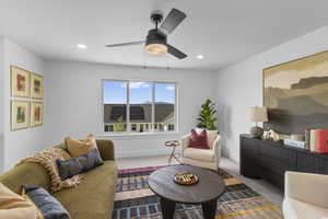 Carpeted living area featuring a ceiling fan and recessed lighting