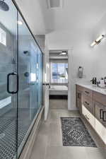 Ensuite bathroom featuring plenty of natural light, vanity, a stall shower, light tile patterned floors, and recessed lighting
