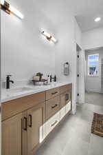 Bathroom with double vanity and light tile patterned floors