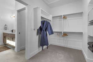 Walk in closet with light tile patterned floors and light carpet