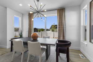 Dining space with light wood-style flooring, recessed lighting, and a chandelier