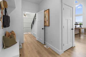Hall featuring a desk, light wood-style flooring, and stairway