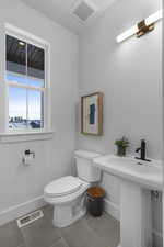 Bathroom featuring toilet and light tile patterned flooring