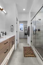 Bathroom with vanity, a shower stall, light tile patterned floors, and recessed lighting