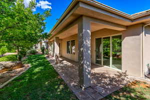 View of property exterior featuring a patio, a yard, and stucco siding