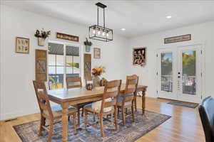 Dining space with french doors, light wood-style flooring, and recessed lighting