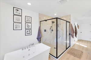 Full bathroom with a freestanding bath and a marble finish shower