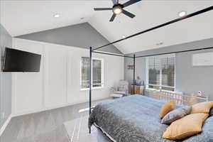 Carpeted bedroom featuring lofted ceiling, ceiling fan, recessed lighting, and a decorative wall